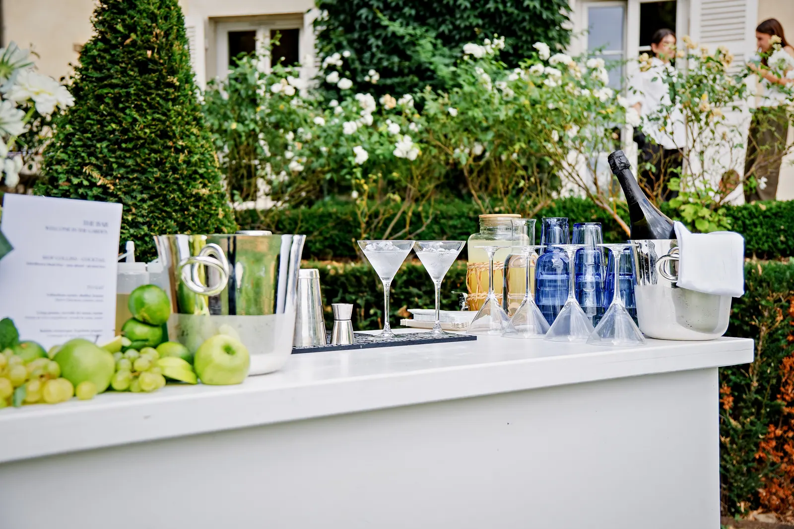 Bar à cocktails dressé dans les jardins d'un château, verrerie fine et verres à martini